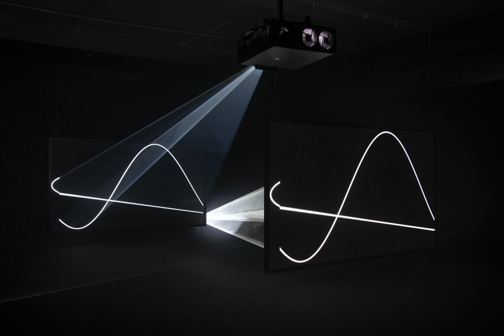 Anthony McCall Solid Light exhibition, two visitors in a beam of light at Tate Modern
