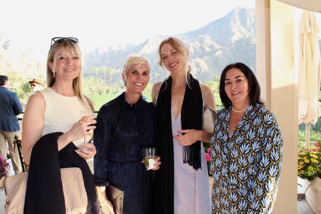 four women pose for a photo in Palm Springs with mountains in the background
