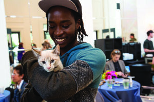 a young animal advocate smiles while holding a kitten