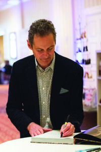 an author smiles while signing a book