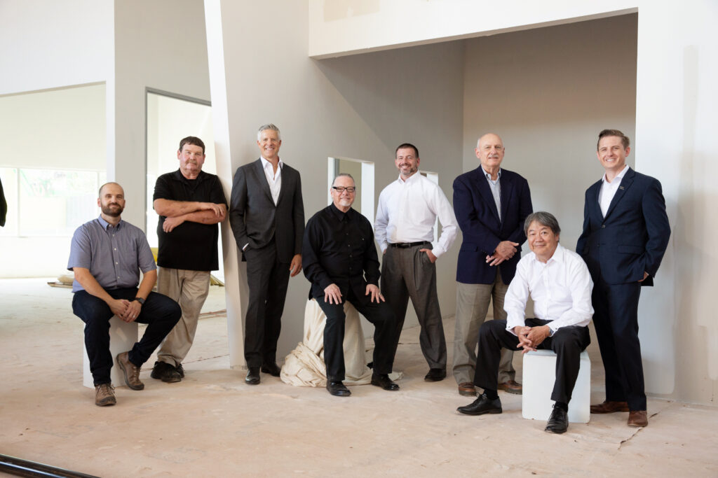 a group of men pose together in an industrial setting