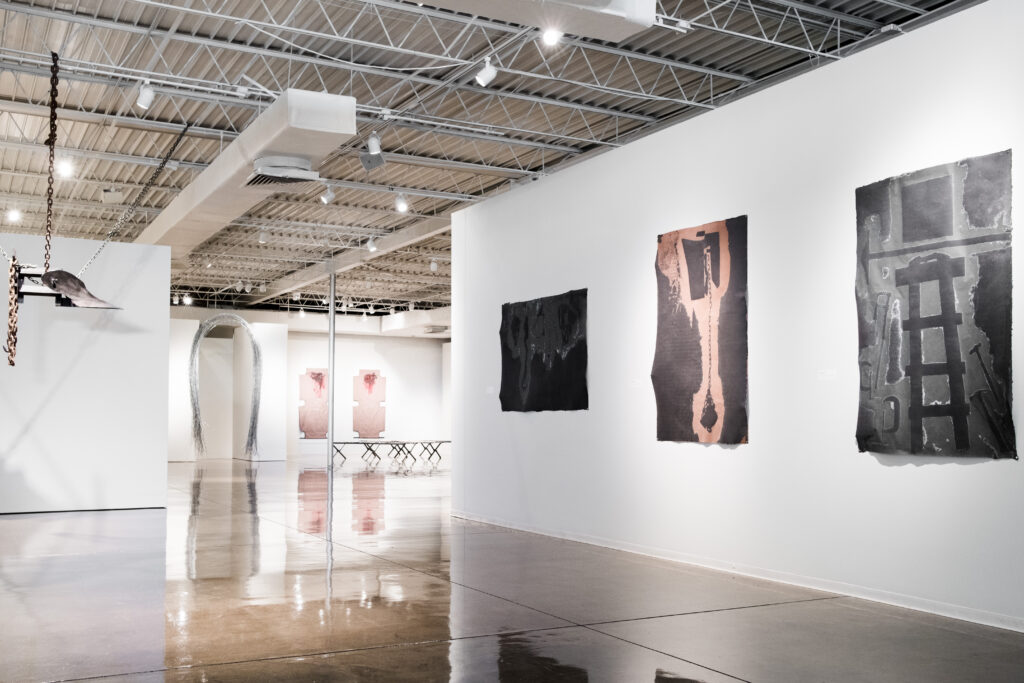 A modern gallery at Oklahoma Contemporary with abstract artworks and sculptural installations from Mel Edwards' "In Oklahoma" exhibition