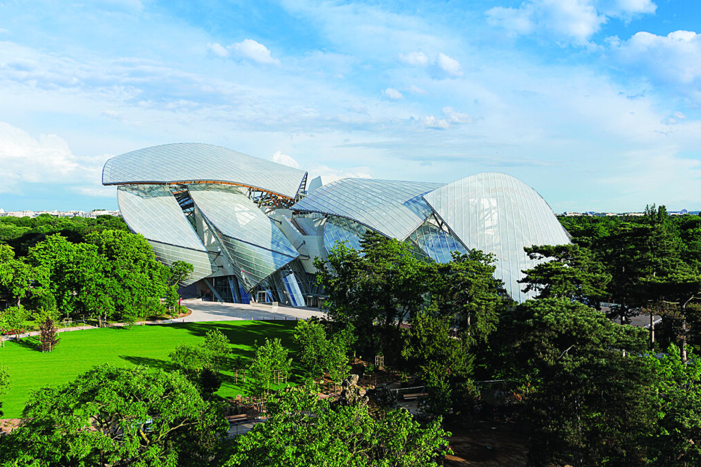 a modern building sits in the middle of a of an urban green space