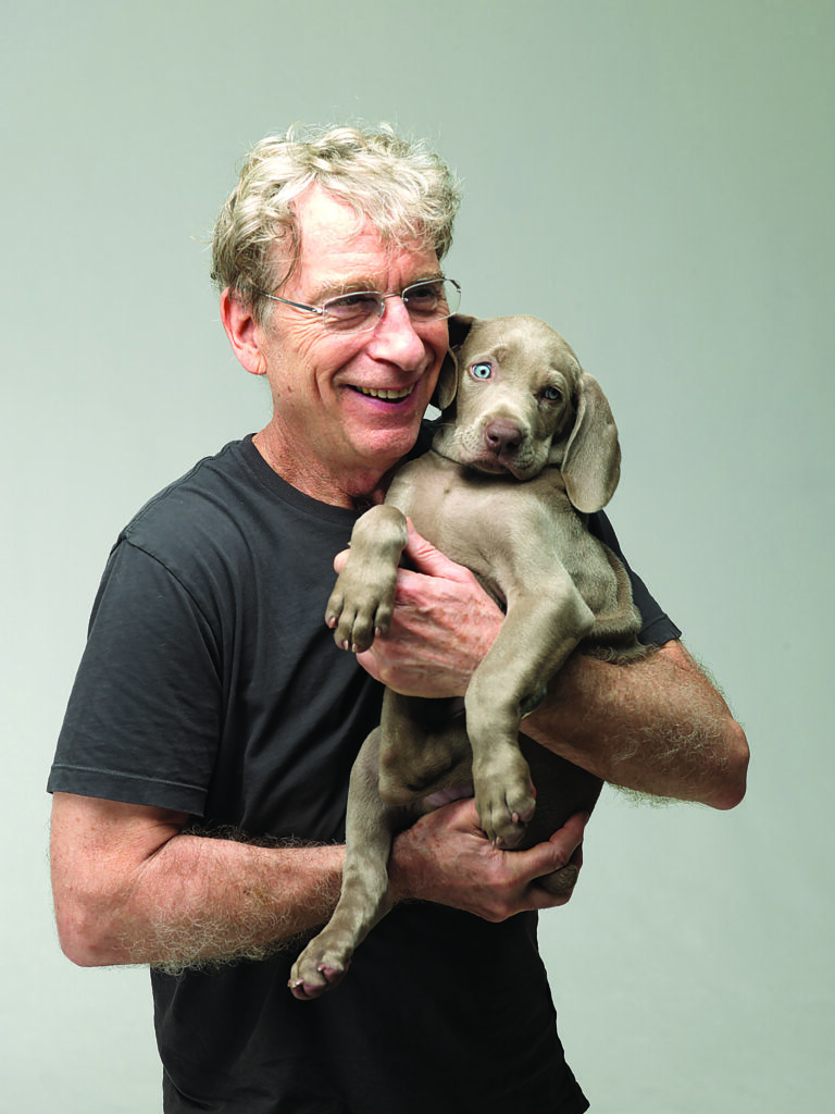 a man holds and snuggles a puppy in his arms