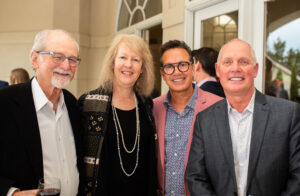 a group of four people pose together for a photo