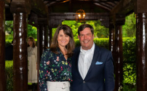 two people pose for a photo in a garden setting