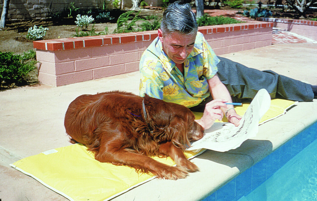 a man and his dog lay on a mat next to a pool and look at a newspaper together