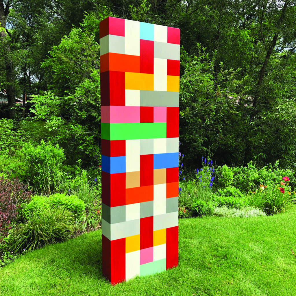 Pard Morrison's "Soul Station," a tall outdoor sculpture made of colorful rectangular blocks, standing on a grassy lawn at the annual Green Box Arts Festival.