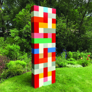 Pard Morrison's "Soul Station," a tall outdoor sculpture made of colorful rectangular blocks, standing on a grassy lawn at the annual Green Box Arts Festival.