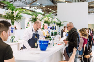 people wait in line at a bar serving wine and champagne