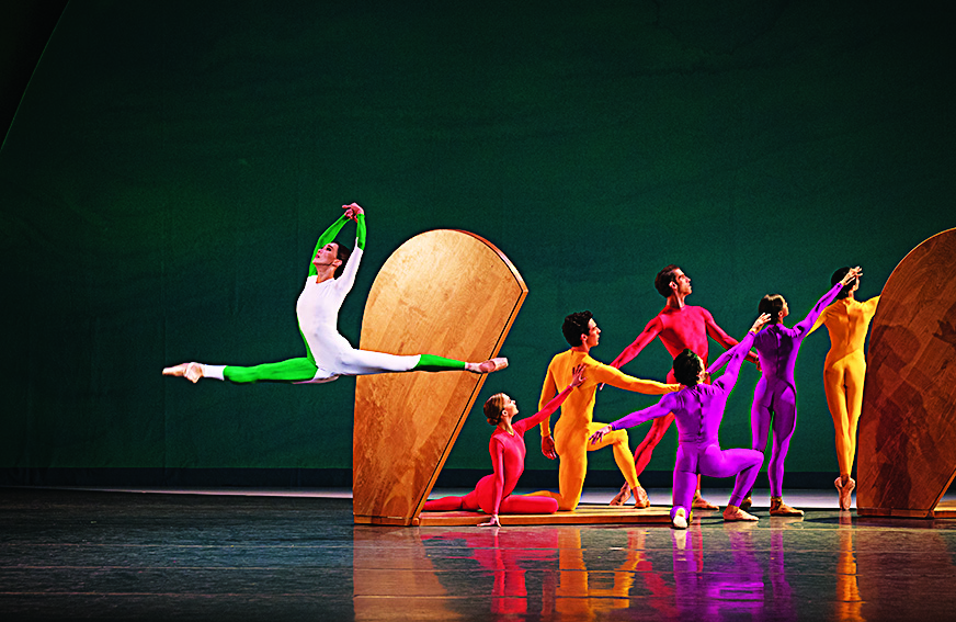 A dance leaps through the air stage left as other dancers look to the right, forming a geometric shape in Jessica Lange's "Garden Blue" ballet