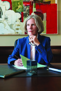 a woman looks to the left while in thought as she sits at a desk