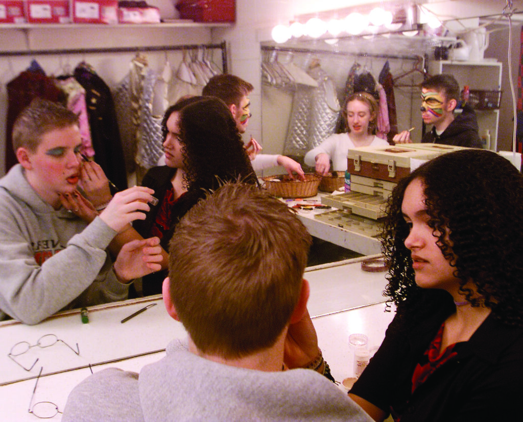 students apply make up in a mirrored studio
