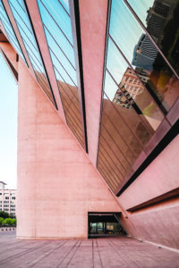 detail of Dallas city hall, with buff angular walls and reflective windows in an angular brutalist style