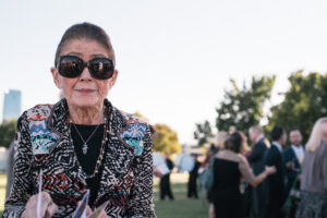 a woman smiles and flips through ArtDesk magazine at a groundbreaking event