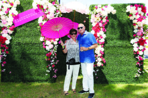 two people pose for a photo in a garden setting