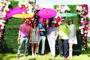 a group of people pose for a photo in a garden setting