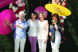 a group of people pose for a photo in a garden setting