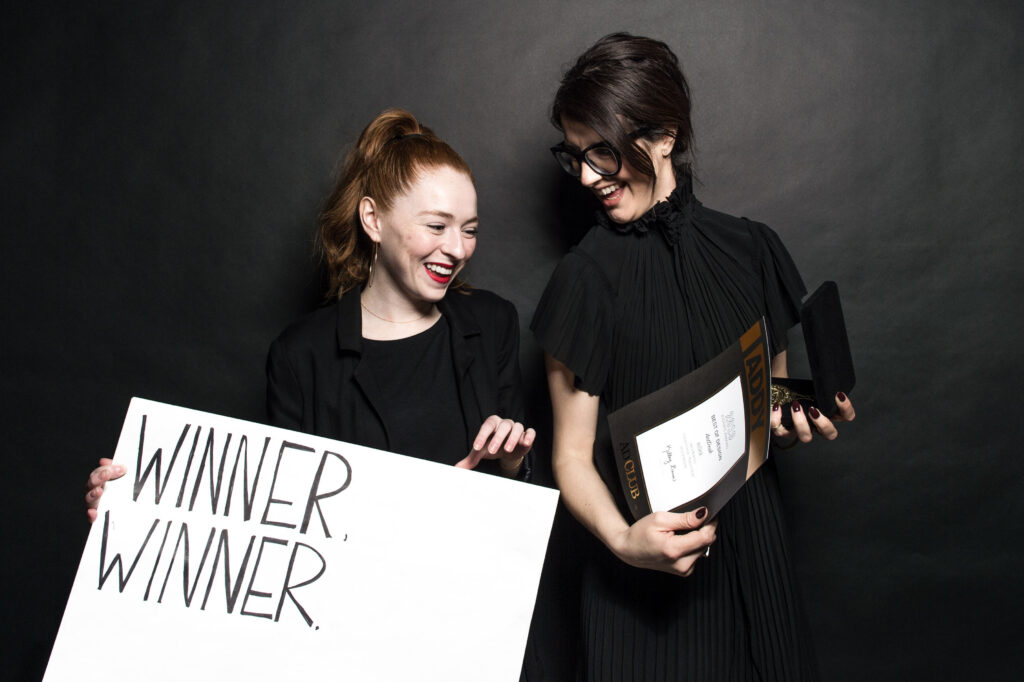 two women accept an award