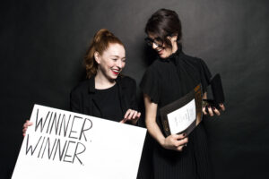two women accept an award