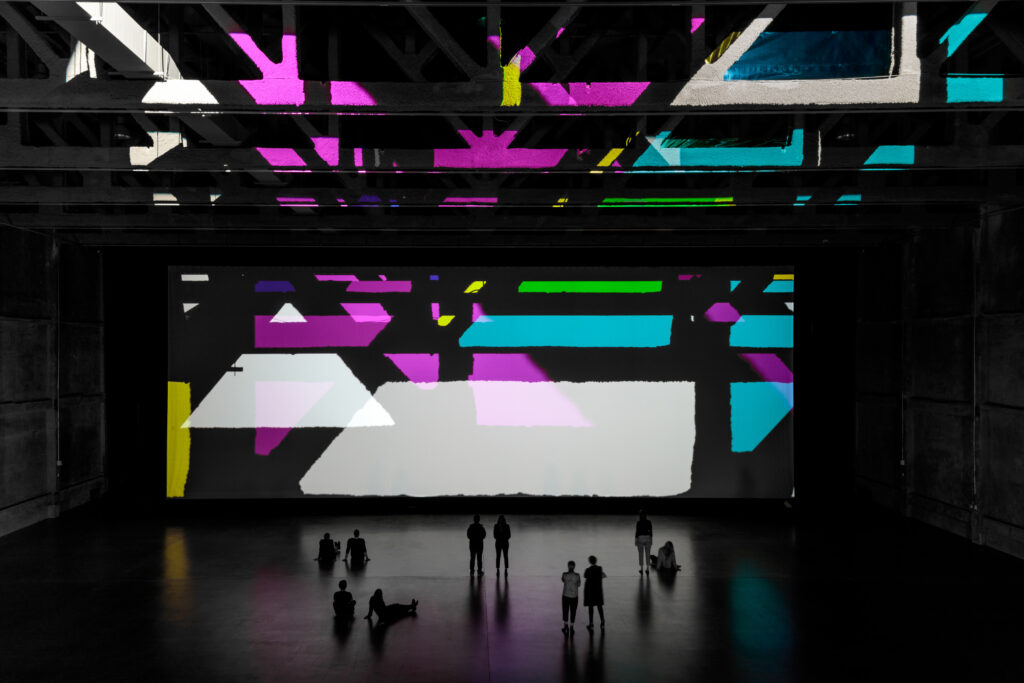 bold lighted shapes are projected on a giant gallery wall