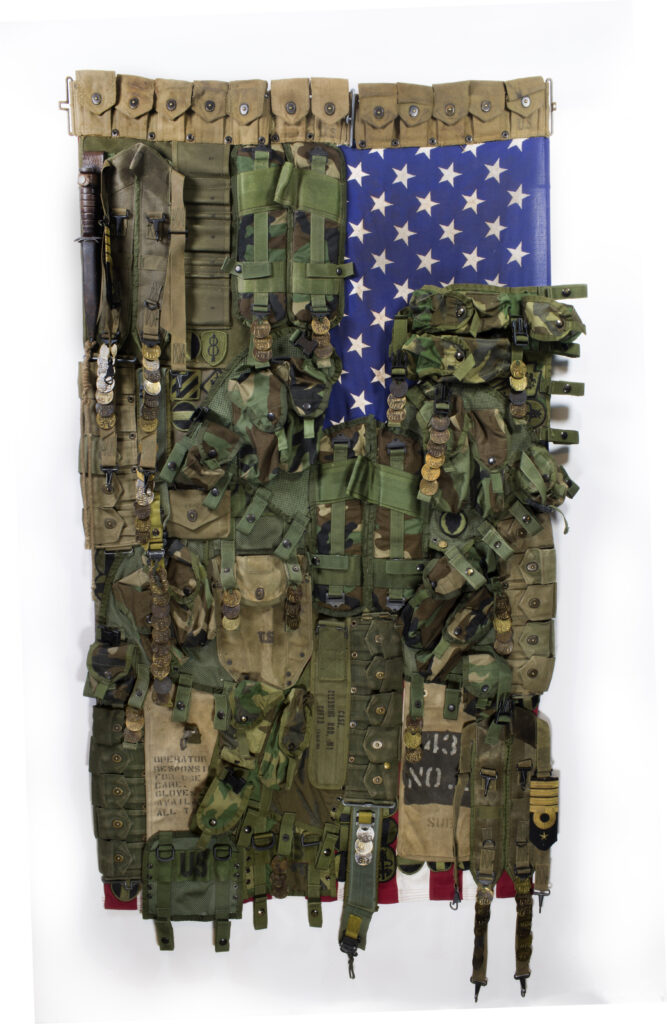 a rendition of the American flag with fatigue green and camo over the flag's red and white stripes and the blue field of stars showing in the corner below