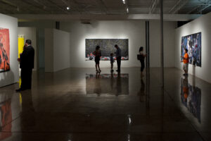 a dramatic, dimly lit art gallery with silhouettes of patrons