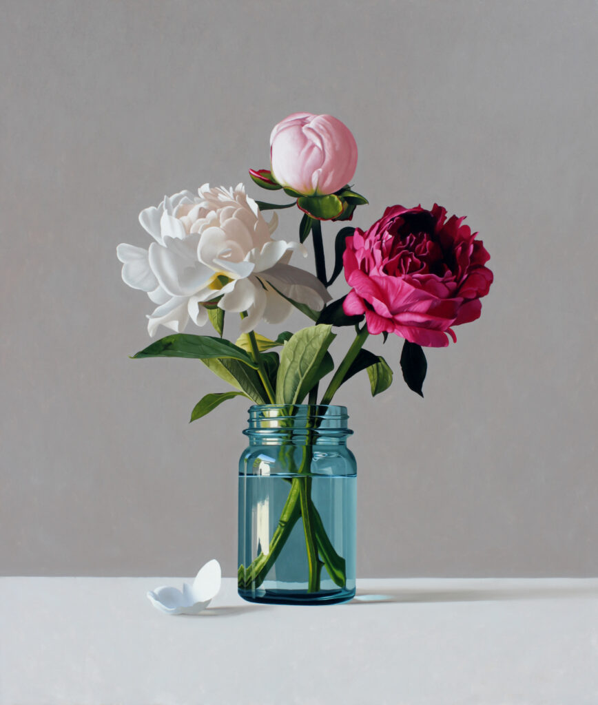 a still life composition of three flowers in a simple blue glass mason jar